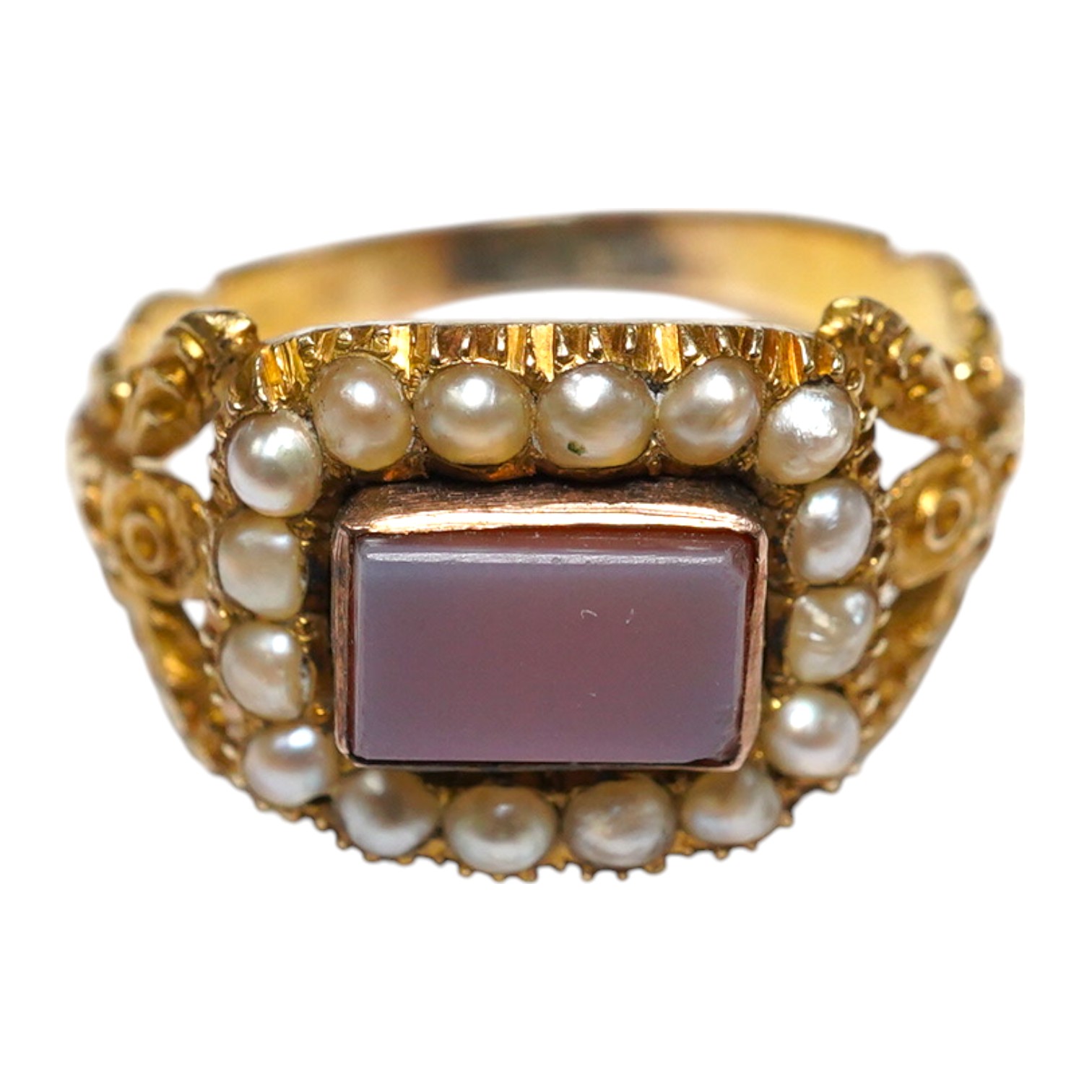 A Victorian yellow metal, carnelian and split pearl set ring, with carved split shoulders, size L, gross weight 2.7 grams. Condition - poor to fair